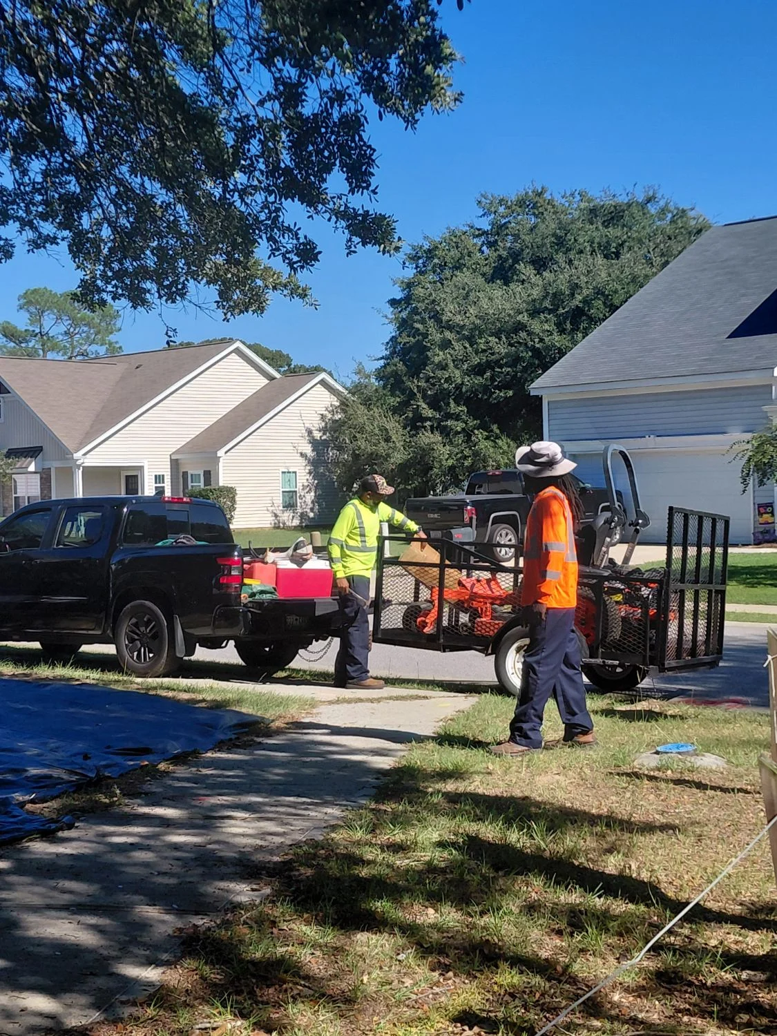 LVJ crew loading a zero-turn mower onto the trailer at a South Carolina home